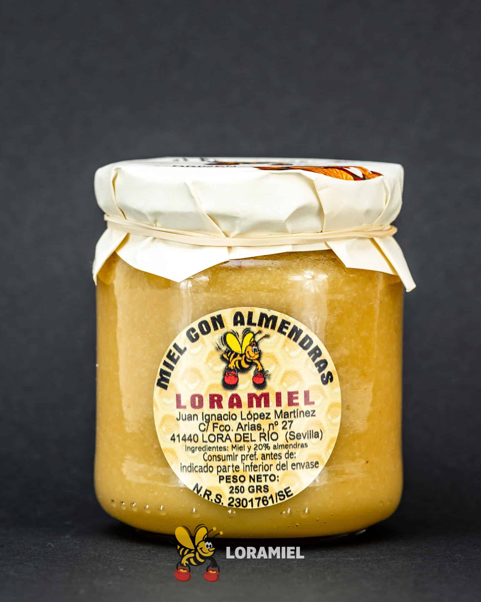 Tarro de miel con almendras Loramiel sobre fondo oscuro, producto artesanal natural elaborado en Sevilla