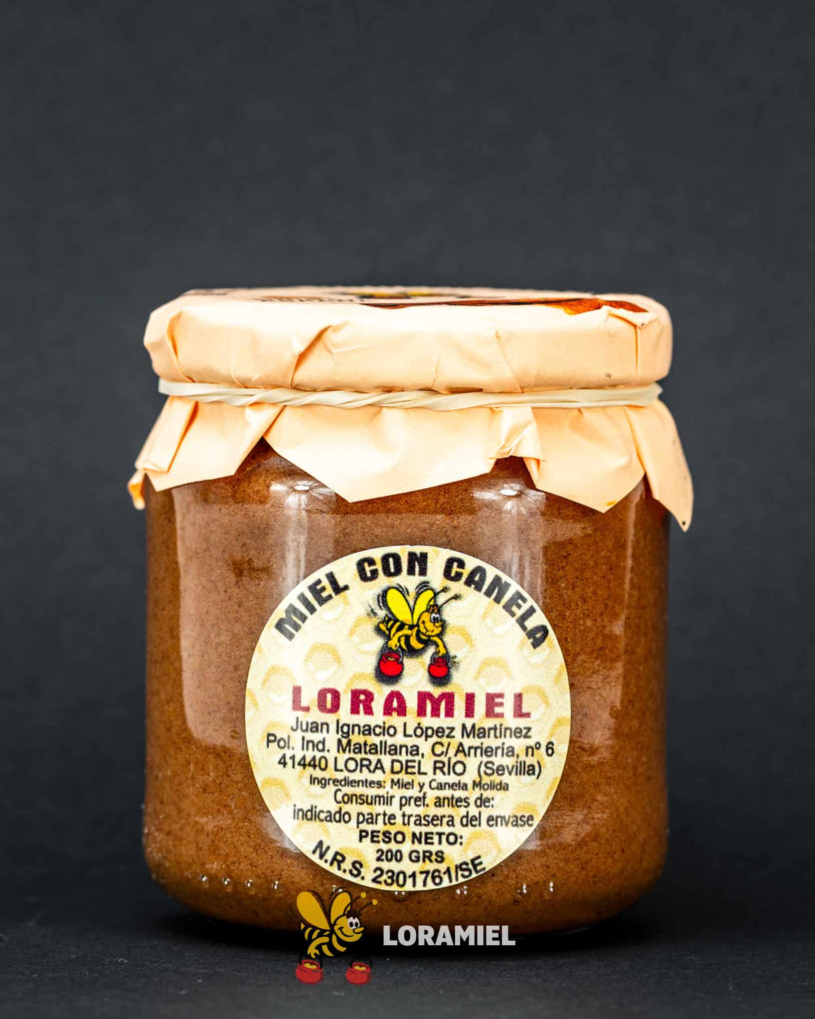 Tarro de miel con canela Loramiel sobre fondo oscuro, producto artesanal natural elaborado en Sevilla